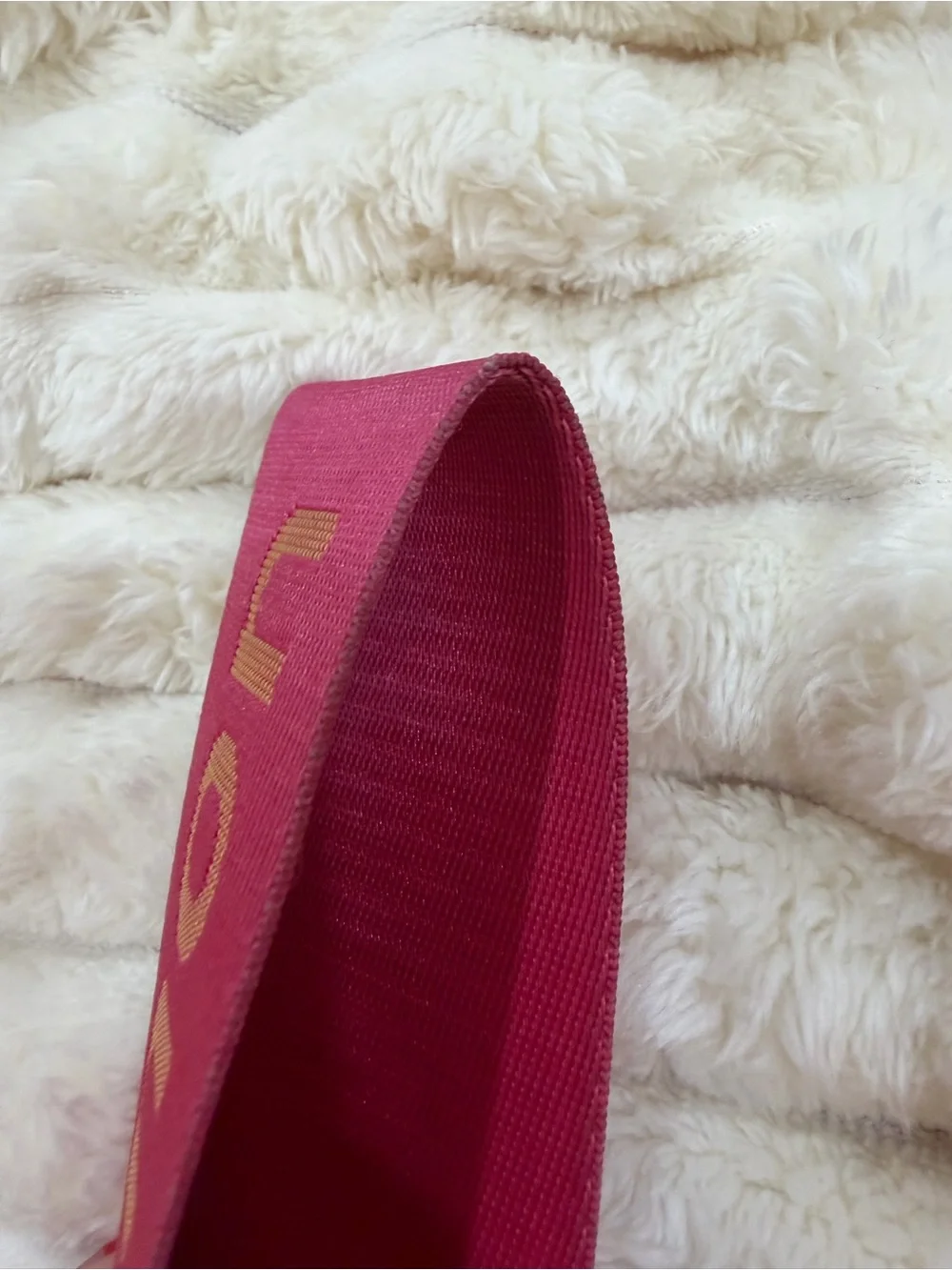 lululemon pink logo wristlet strap with orange lettering